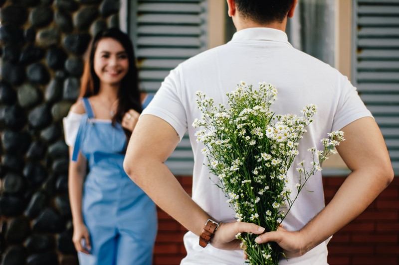 Ein Mann schenkt einer Frau Blumen