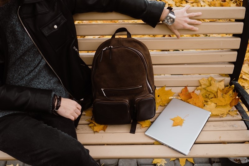 Person sitzt auf einer Bank im Herbst