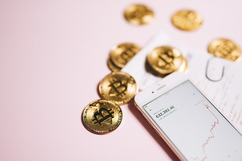 Bitcoin-Münzen und Bitcoin-Kurs auf Smartphone