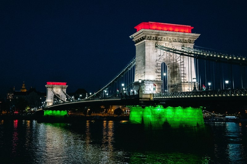 Brücke in Budapest erstrahlt bei Nacht in Landesfarben