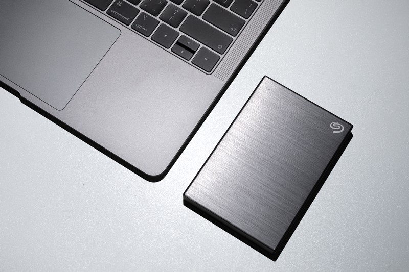 Externe SSD-Festplatte neben Laptop zur Datensicherung