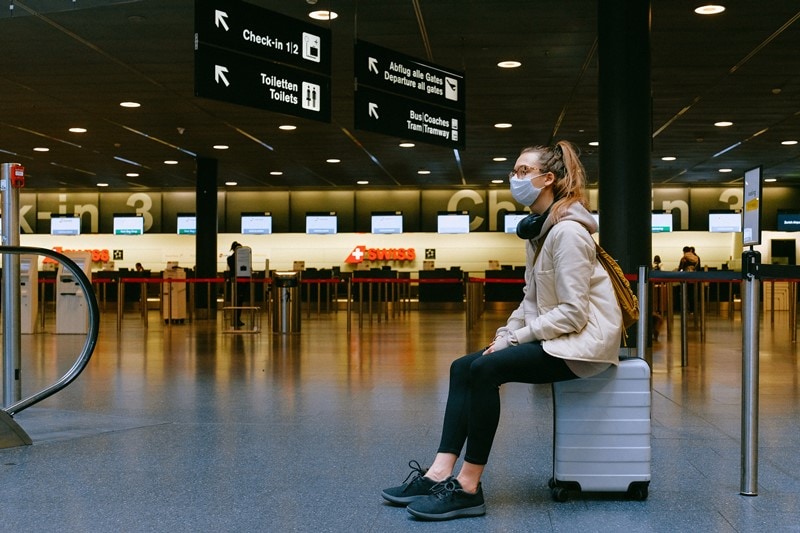 Frau mit Koffer am Flughafen