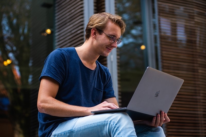 Mann nutzt Laptop im Freien