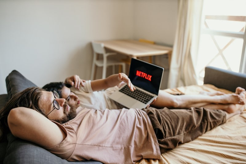 Paar im Bett streamt Netflix auf dem Laptop