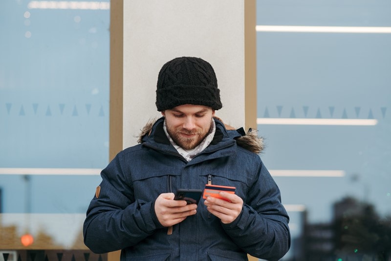 Mann bezahlt online über Smartphone