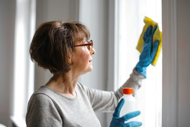 Frau reinigt Fenster