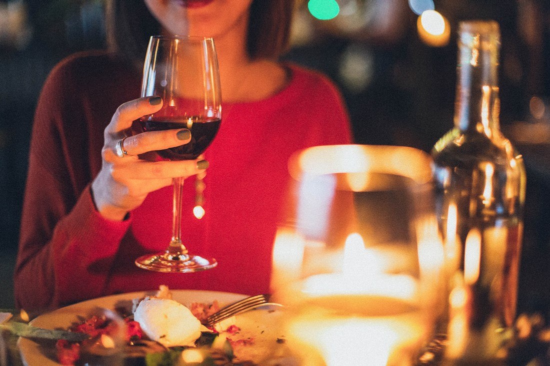 Frau trinkt Wein zum Essen